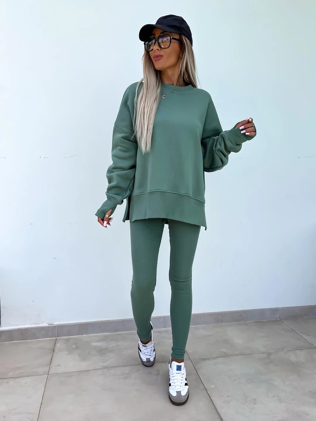 A green  outfit with a round-neck, long and loose sweatshirt and high-elasticity slim-fit trousers. Model shows the front wearing this suit.