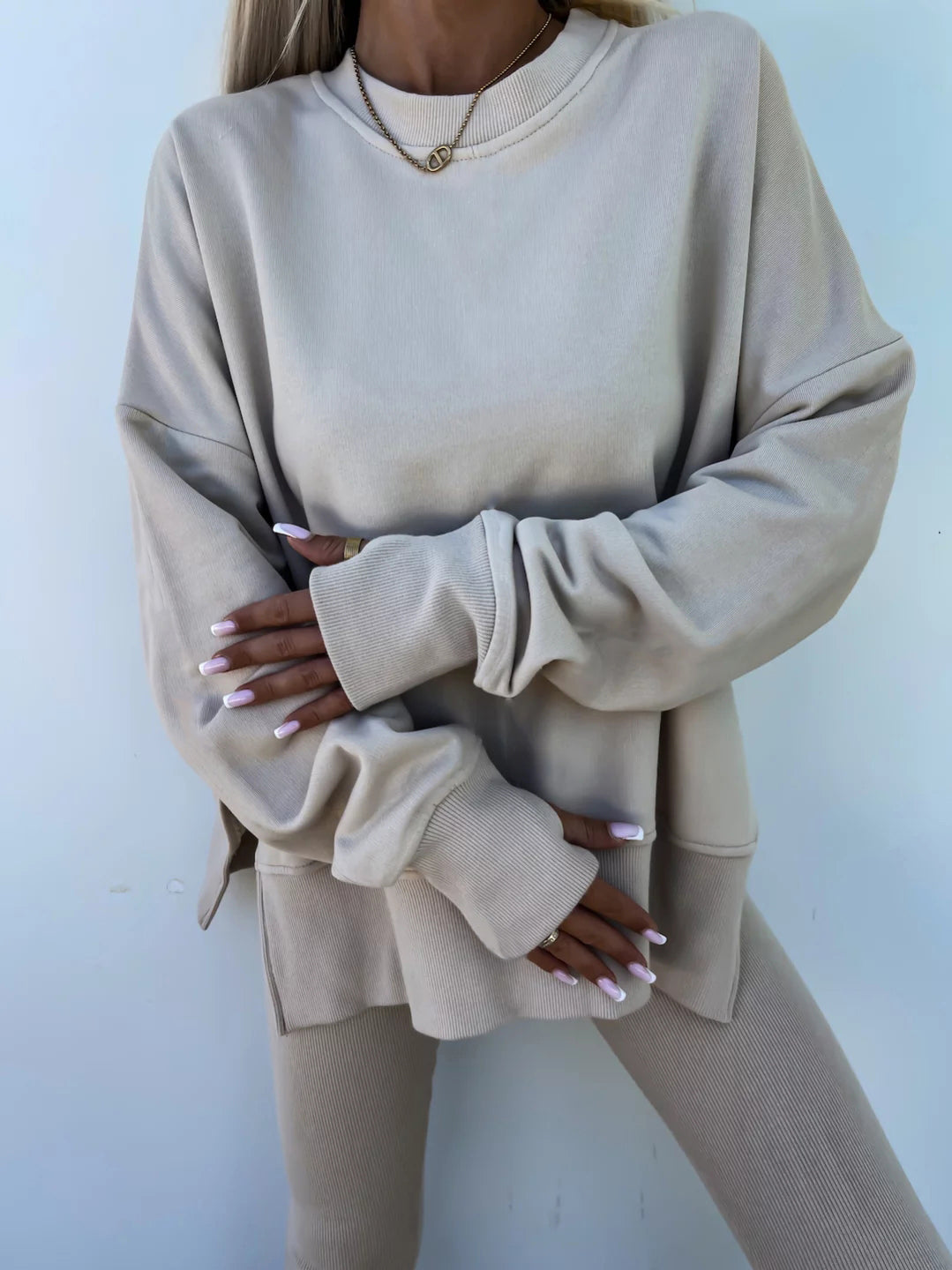 A leisure suit consisting of a round-neck, long, loose sweatshirt and high-elasticity slim-fit trousers. The model is wearing it for display.